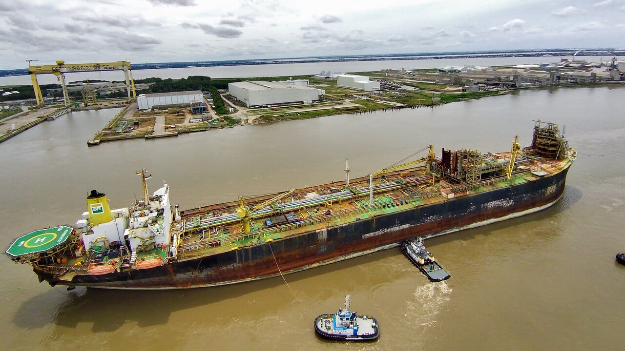 A plataforma P-32 da Petrobras chegou ao Estaleiro Rio Grande para iniciar um inovador processo de reciclagem sustentável em solo brasileiro. Adquirida pela Gerdau em leilão, a plataforma será desmantelada pela Ecovix, com a sucata metálica sendo utilizada na produção de aço.