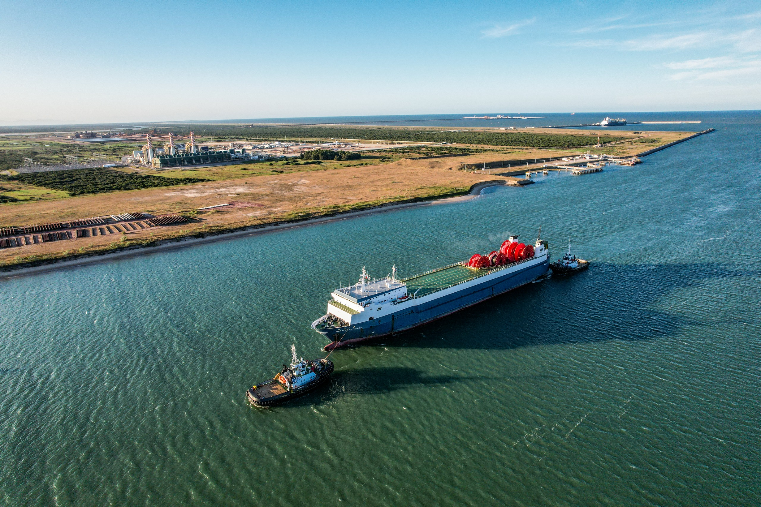 Vista aérea do Porto do Açu com navio e guindastes, destacando sua importância para a energia eólica offshore no Brasil.