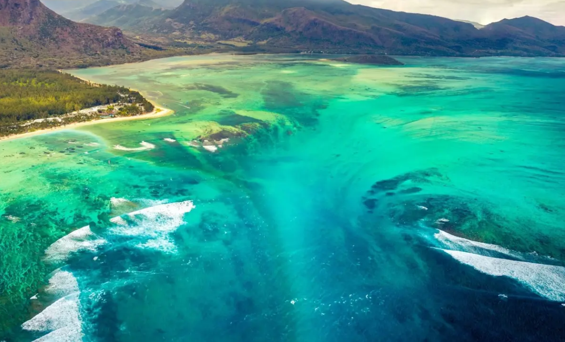 Esto sucede porque las aguas frías de los mares nórdicos se encuentran con las aguas cálidas del Atlántico, creando una diferencia de densidad. Este contraste hace que el agua «caiga» al fondo del océano, formando la cascada.