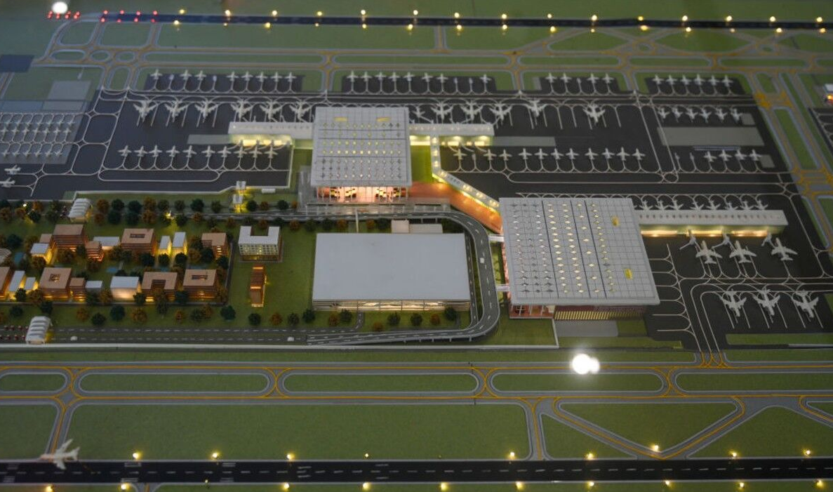 El nuevo aeropuerto tendrá una área total de 1.334 hectáreas, equivalente a más de 1.800 campos de fútbol. Cuando esté totalmente concluido, contará con cuatro terminales y seis pistas, pudiendo atender 70 millones de pasajeros por año, convirtiéndose en el mayor de India.