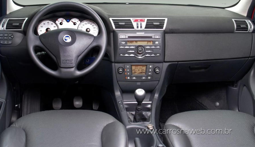 El panel del Fiat Stilo 1.8 2007 tiene un acabado soft touch en la parte superior, mandos bien posicionados y un diseño moderno para la época. Cuenta con panel de instrumentos digital, ordenador de a bordo completo, velocímetro digital, regulación de iluminación, aire acondicionado digital de doble zona y un potente sistema de sonido con reproductor de CD y MP3, pero sin Bluetooth.