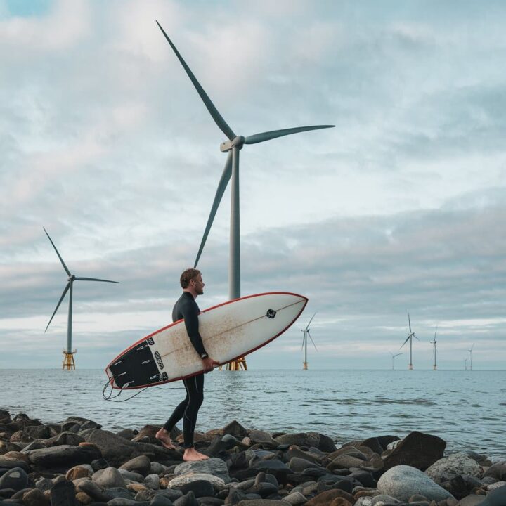 Imagem ilustrando um surfista com uma prancha sustentável ao lado de parques eólicos.