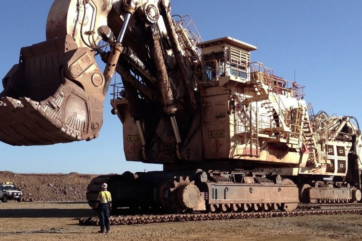 Conheça a RH400, uma lendária escavadeira gigante! Descubra sua história, força de ~980t, capacidade de 100t/pá e seu impacto na mineração mundial