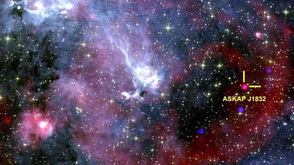 Imagem espacial com destaque para o objeto ASKAP J1832, entre estrelas e nuvens de gás no universo profundo.