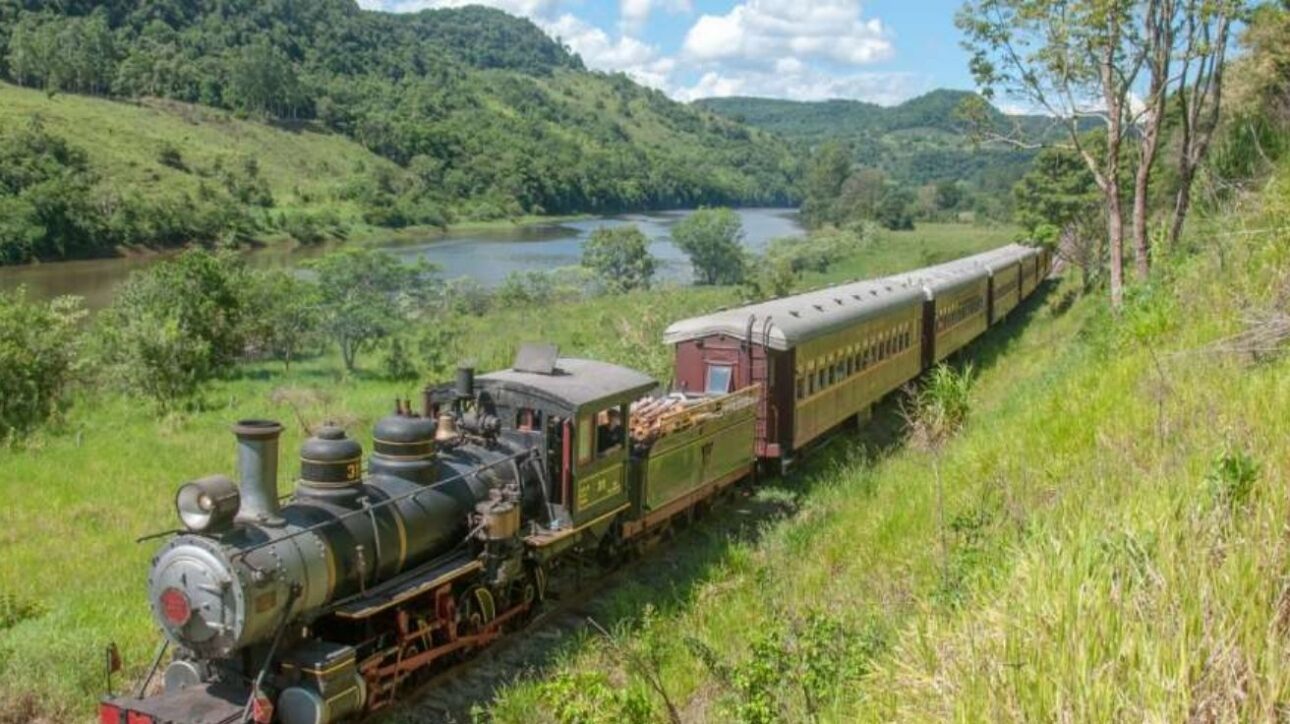 Viaje por una ferrovia histórica en SC por menos de R$ 100, cruzando túneles y puentes con vista para la mata nativa a bordo de una Maria Fumaça. (Imagen: site Viagens Sem Caminho)