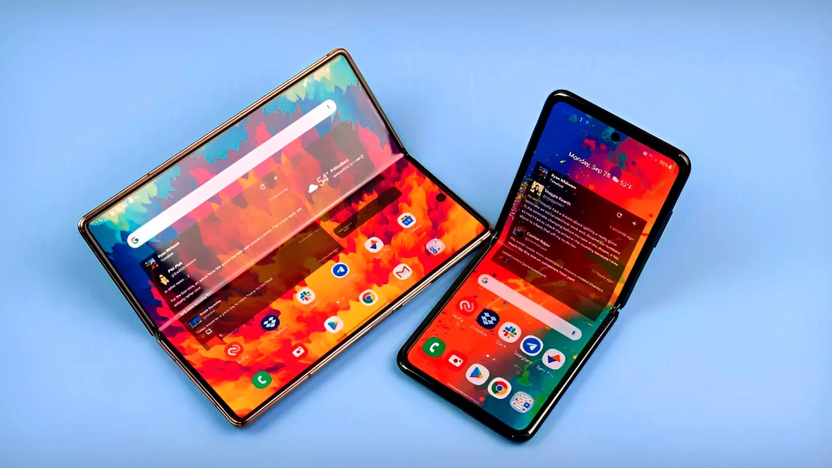 Dois celulares dobráveis com telas abertas exibindo interface colorida sobre fundo azul
