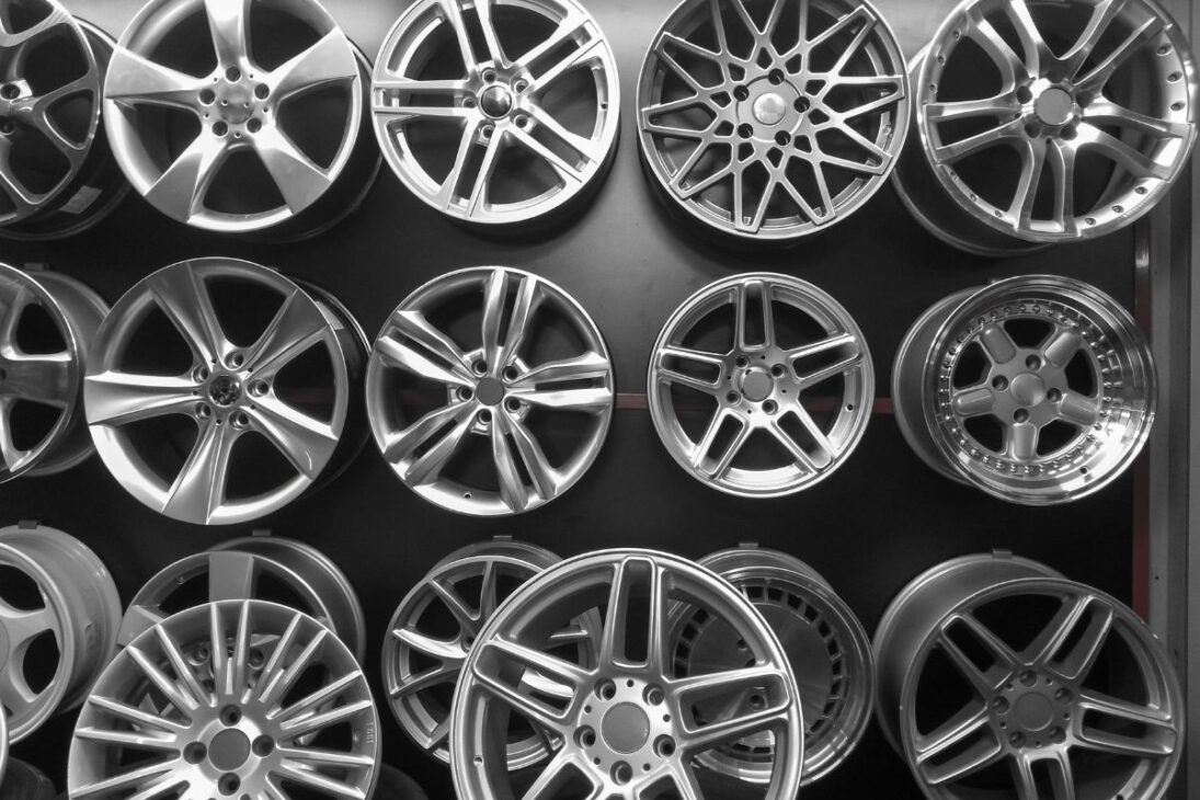 Varias ruedas de aleación ligera con diferentes modelos y diseños expuestas en una pared, destacando la variedad de estilos automovilísticos.