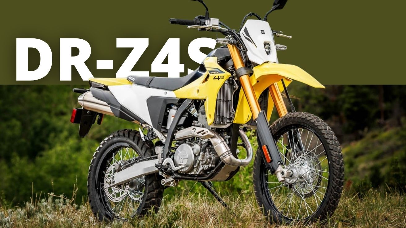 Piloto com traje azul conduz a nova Suzuki DR-Z4S 2025 em estrada de asfalto ladeada por rochas e vegetação típica do interior dos Estados Unidos