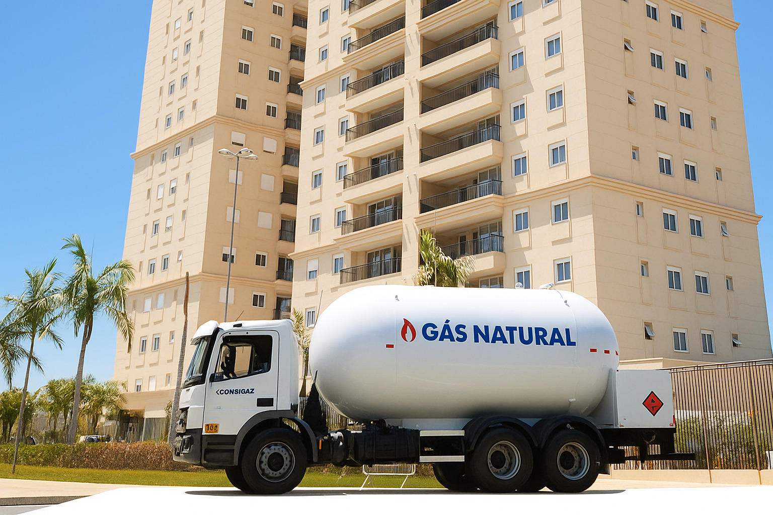 Caminhão-tanque de gás natural estacionado em frente a prédio residencial durante o dia.