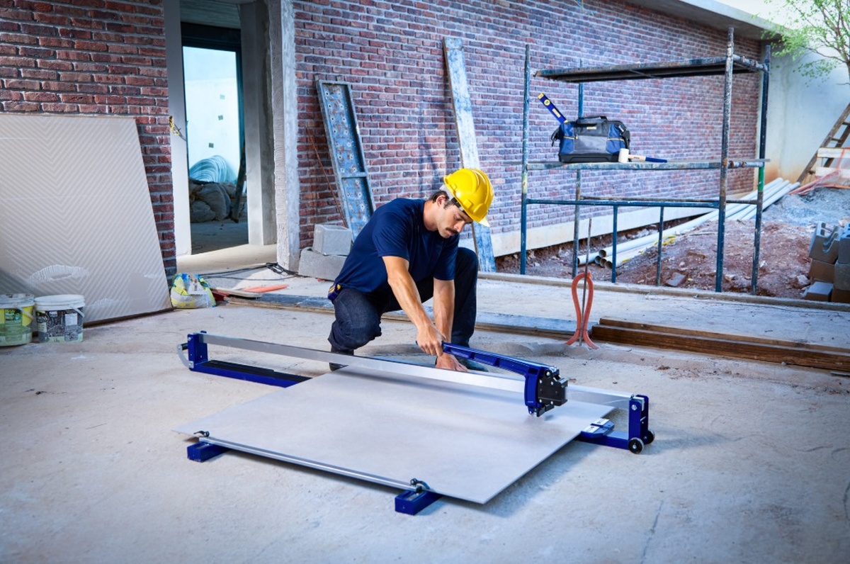 Trabalhador utilizando cortador de piso em obra de construção civil