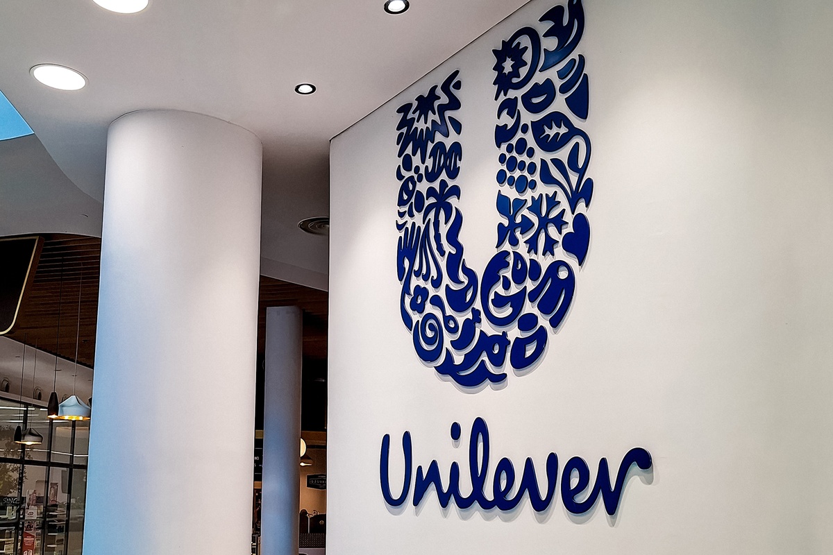 Logo azul da Unilever em parede de escritório corporativo moderno