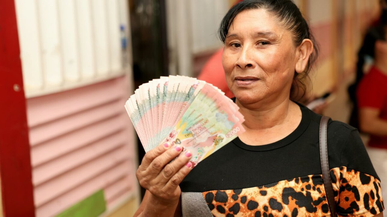 Beneficiario sostiene beneficio en especie y evidencia el impacto directo de los cheques “cash grant” en R$ para la población de la Guayana. (Imagen: Guyana Standard)