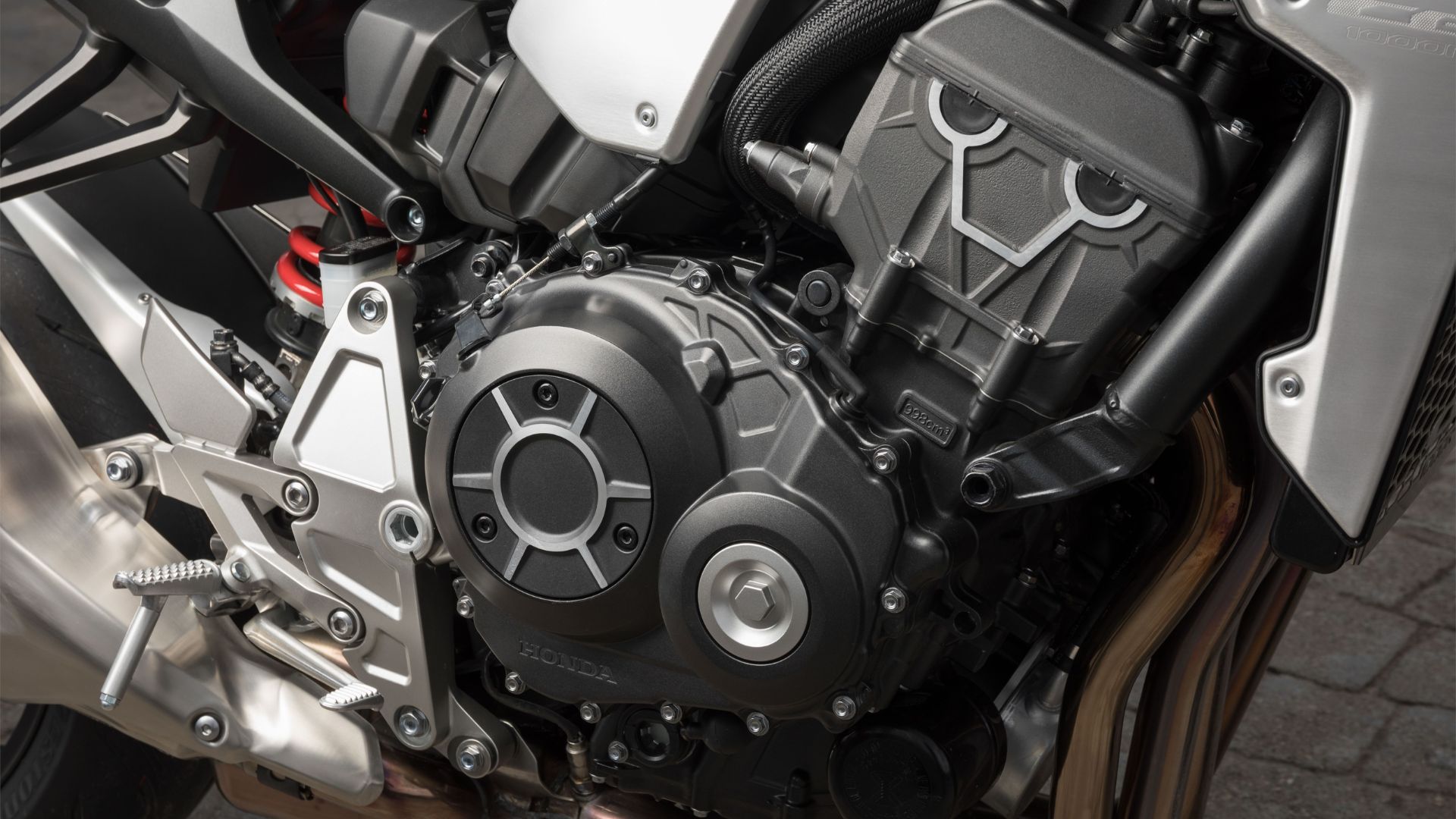 Motor tetracilíndrico Honda destaca potência, alto giro e som marcante, tradição mantida em novas gerações de esportivas. (Imagem: Honda UK)