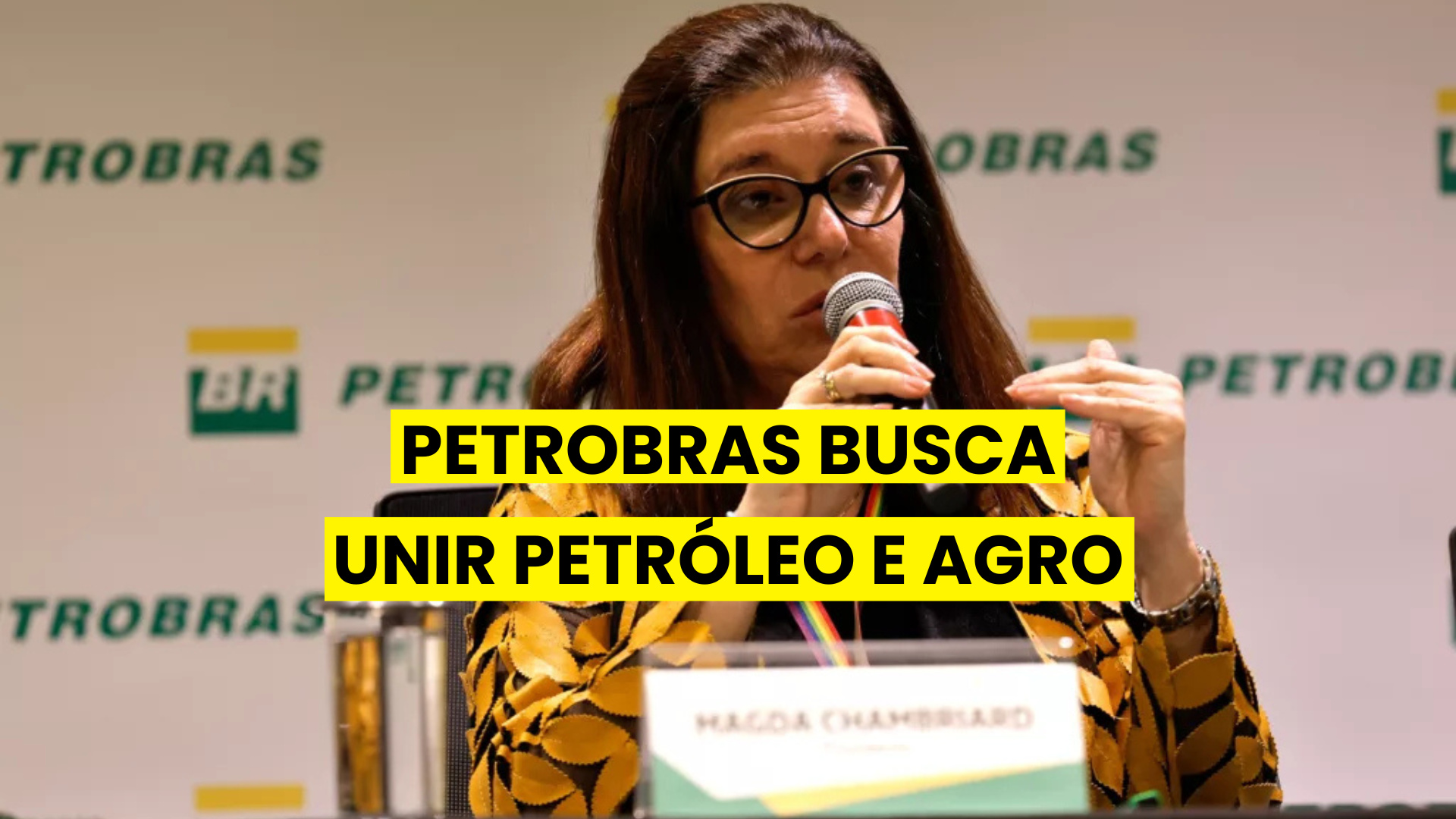 Magda Chambriard, presidente da Petrobras, em evento com painel da empresa ao fundo e o texto 'Petrobras busca unir petróleo e agro' sobreposto.