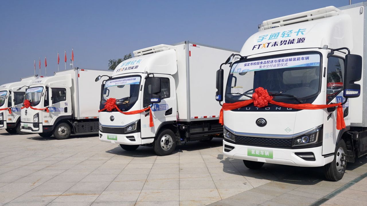 Frota de caminhões comerciais leves da Yutong com branding FTX Future Logistics, alinhados em evento promocional na China, com destaque para inovação em logística sustentável