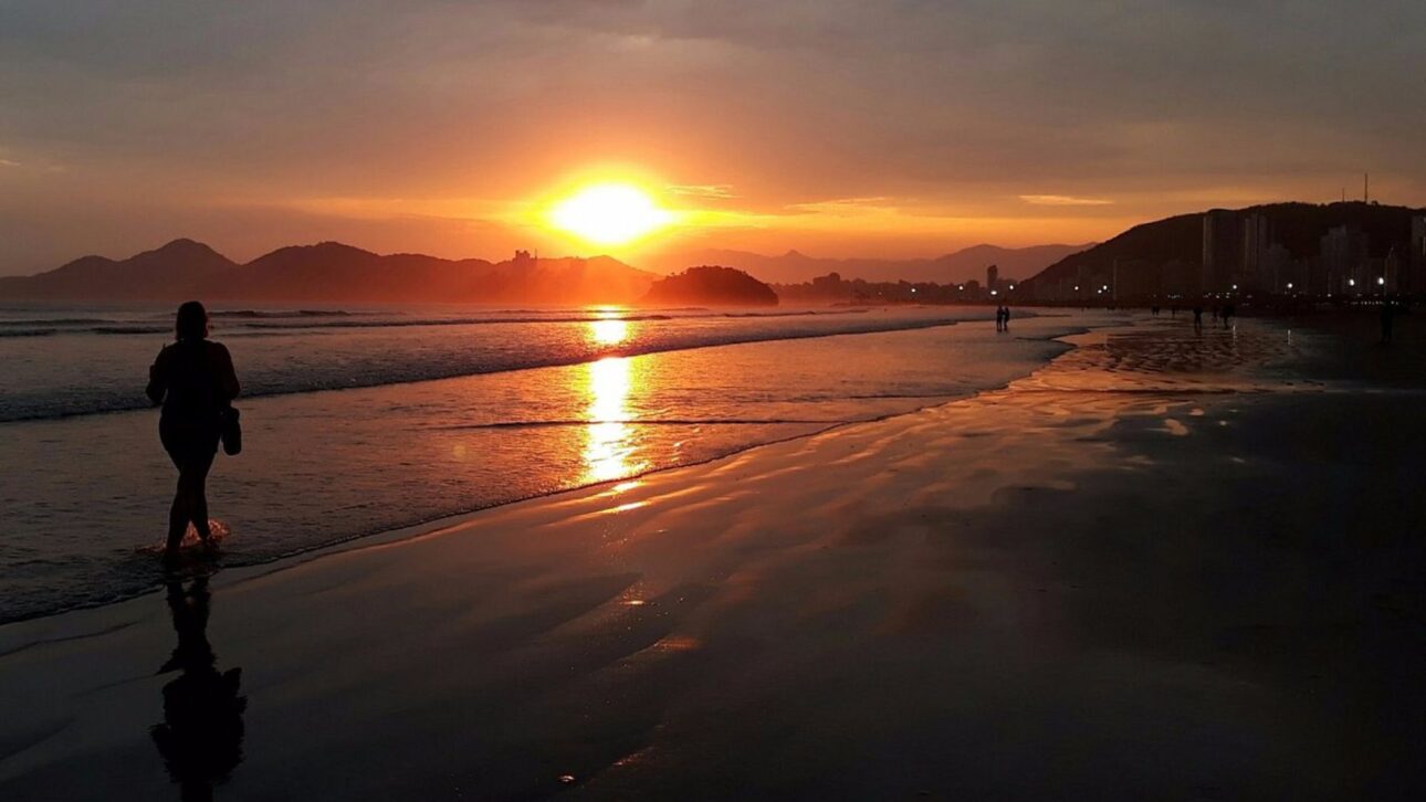 Puesta de sol reflejada en la franja de arena, jardines y mar de la orla de Santos-SP en un momento tranquilo. (Imagen: Reproducción / Pinterest)