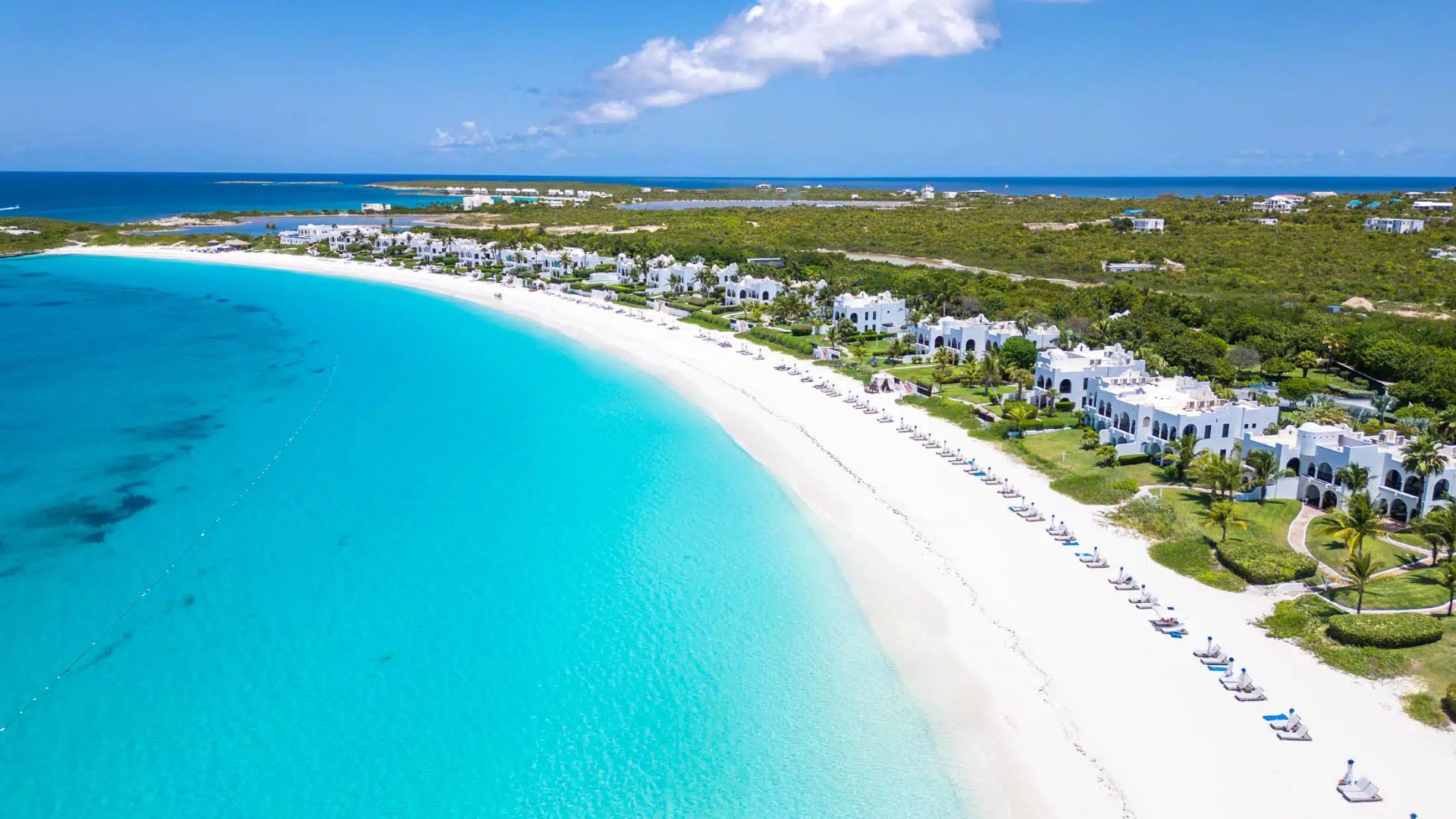 Ilha de Anguilla ao pôr do sol com sobreposição digital “.ai”, representando o novo boom econômico causado pela IA.