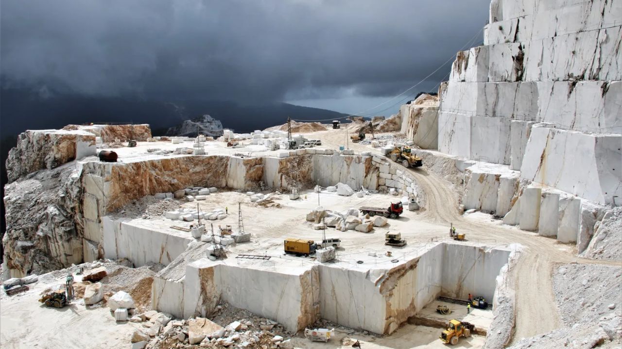 Em paredões verticais de 200 metros, cortadores de pedra usam fios de diamante para fatiar montanhas inteiras e extrair o mármore branco mais luxuoso e caro da arquitetura mundial