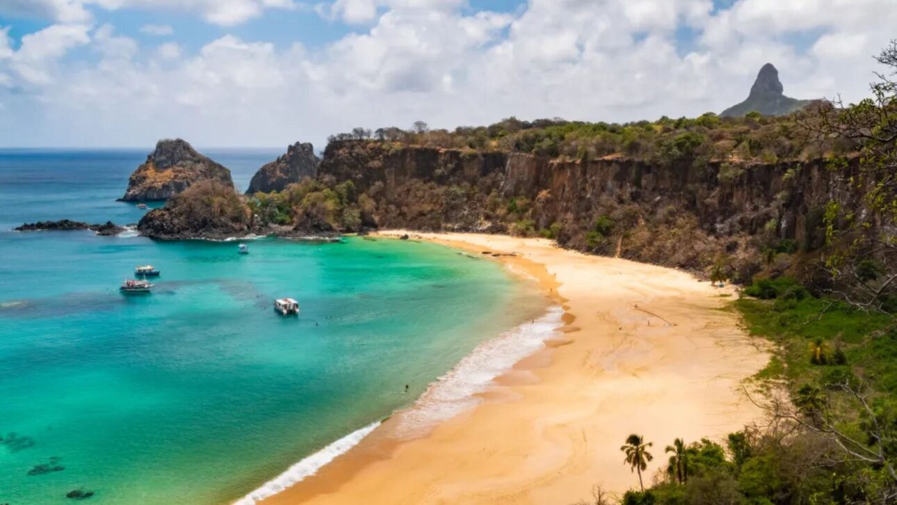 Playa de la Bahía do Sancho en Fernando de Noronha con visibilidad marina de hasta 50 metros y acantilados cubiertos por la vegetación nativa.” (Imagen: Wikipedia-Bahía do Sancho)