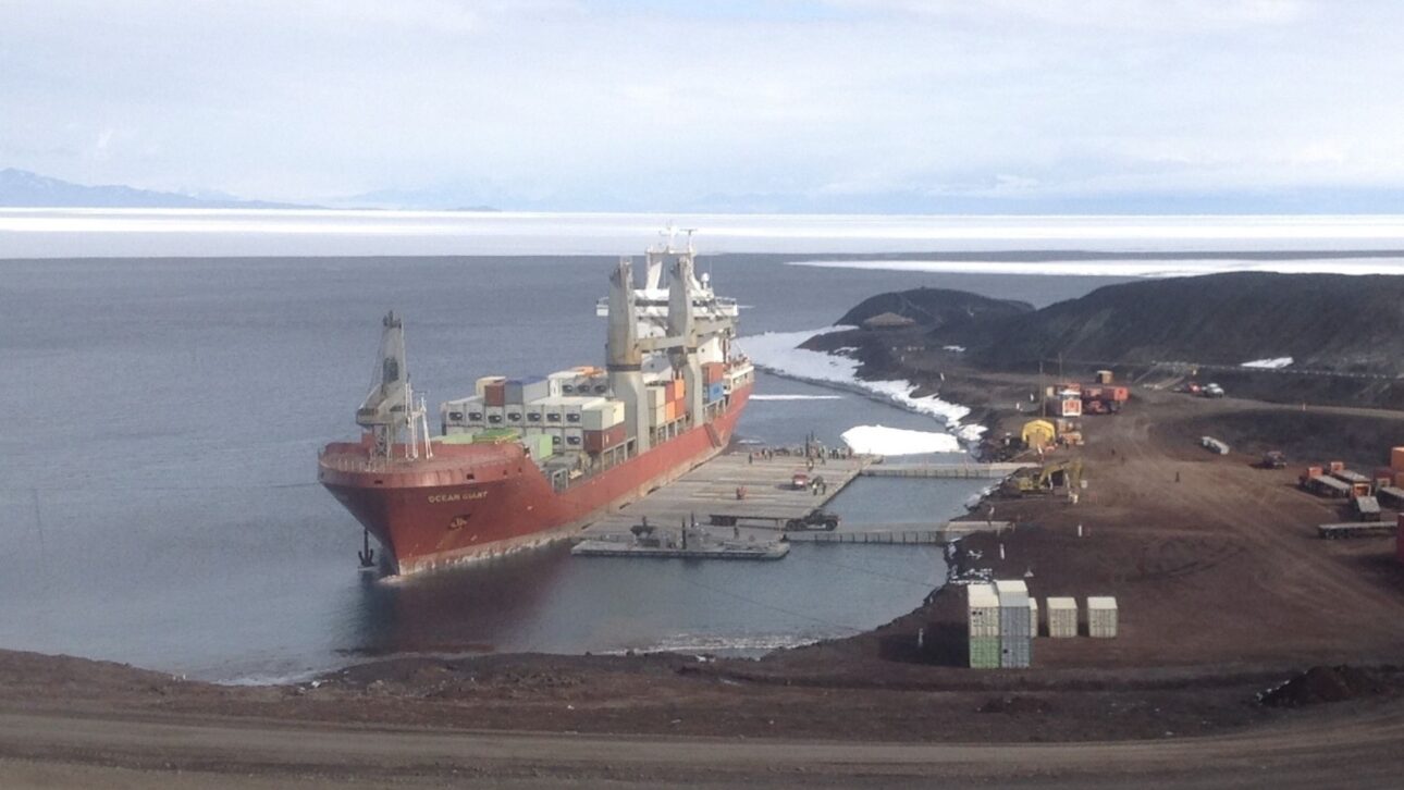 Barco carguero atracado en el muelle de hielo de la Estación McMurdo cargado de suministros. (Imagen: MV Ocean Giant junto al muelle de hielo de McMurdo, con contenedores apilados)