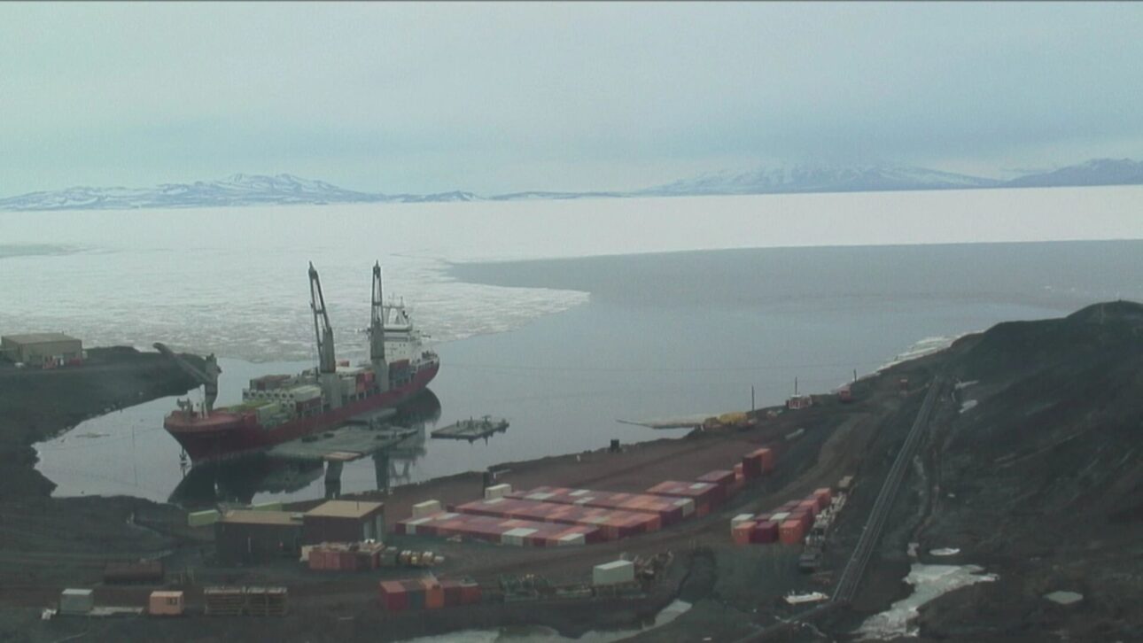 Operación de descarga de contenedores y suministros durante la misión anual de reabastecimiento. (Imagen: contenedores y grúas en operación en el muelle de la Estación McMurdo)