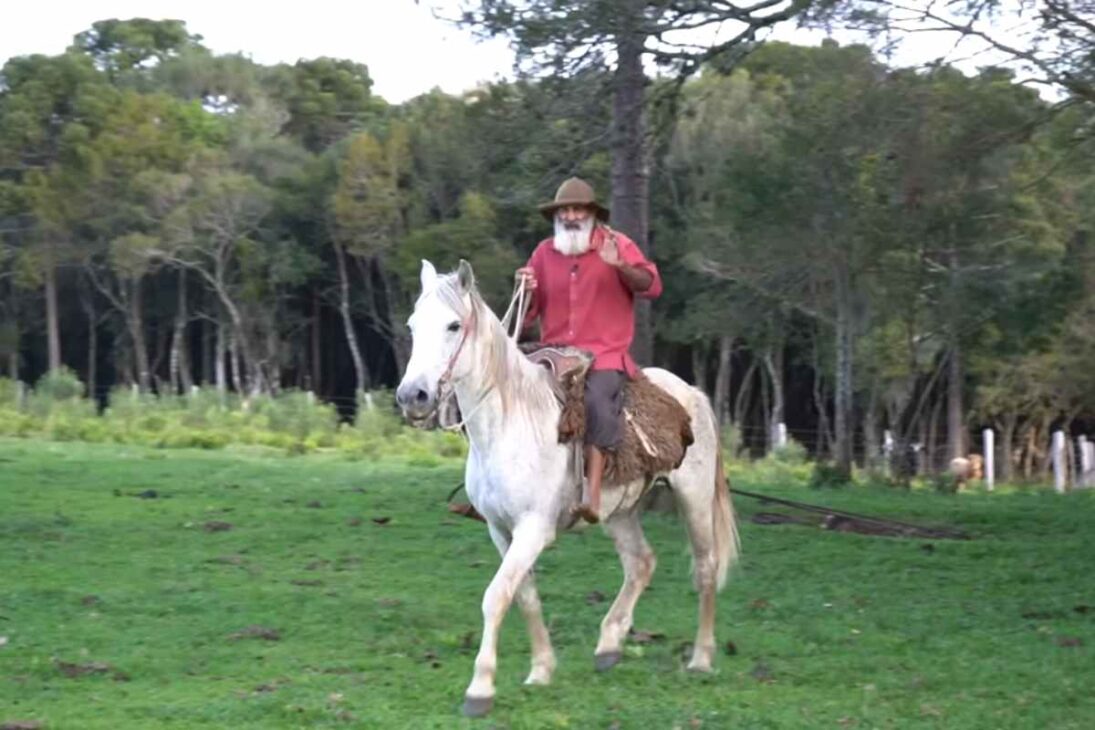 Historia de un agricultor de 70 años que vive con la madre de 90, mantiene una vida auténtica, cuida del jardín, usa el caballo en el día a día y preserva tradiciones en el interior catarinense.