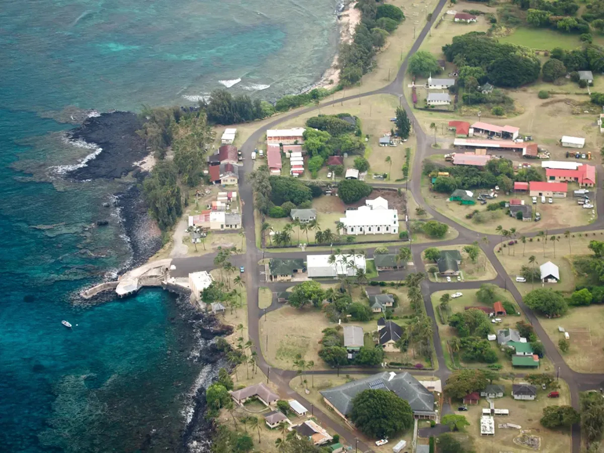 Aérea de Kalawao na península de Kalaupapa, mostrando casas isoladas, área costeira silenciosa e a paisagem remota ligada à antiga colônia de hanseníase.