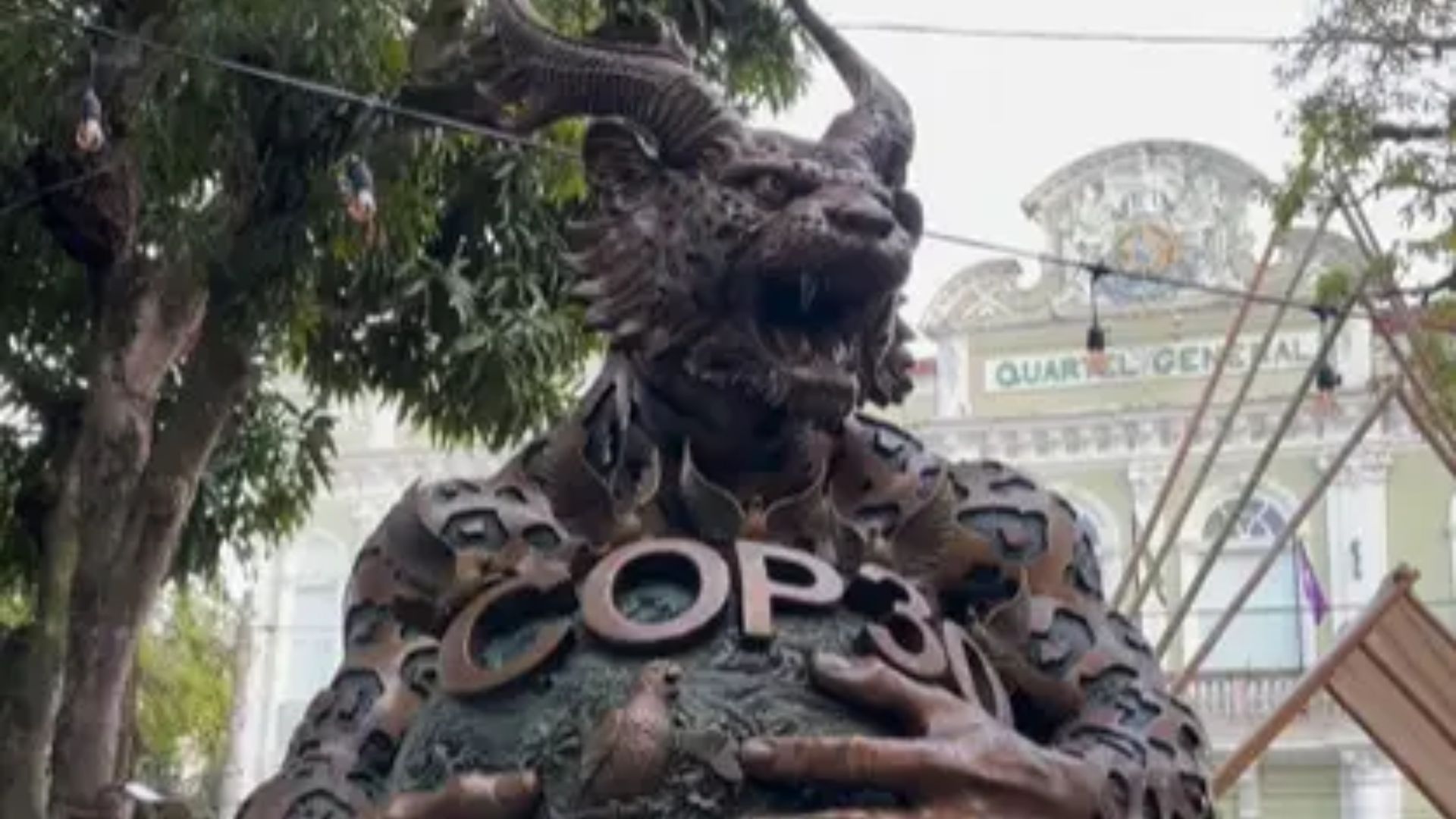 Escultura Dragão-Onça da COP30 exposta em praça pública, misturando dragão chinês e onça amazônica, acompanhada por visitantes e repercussões religiosas.