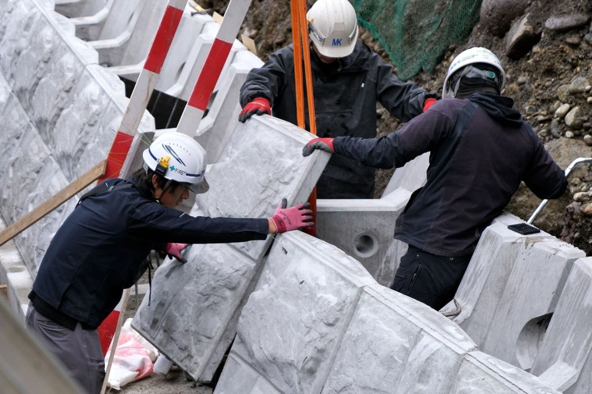 Engenharia extrema reconstrói paredão com blocos gigantes, ajustes milimétricos e concreto armado após tufões devastarem a costa, em obra crítica de seis etapas para conter erosão