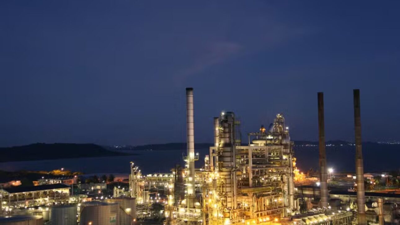Chimeneas y tanques de la Refinería de Mataripe iluminados al atardecer, símbolo de la infraestructura de refinación de Bahía. (Imagen: reproducción pública)
