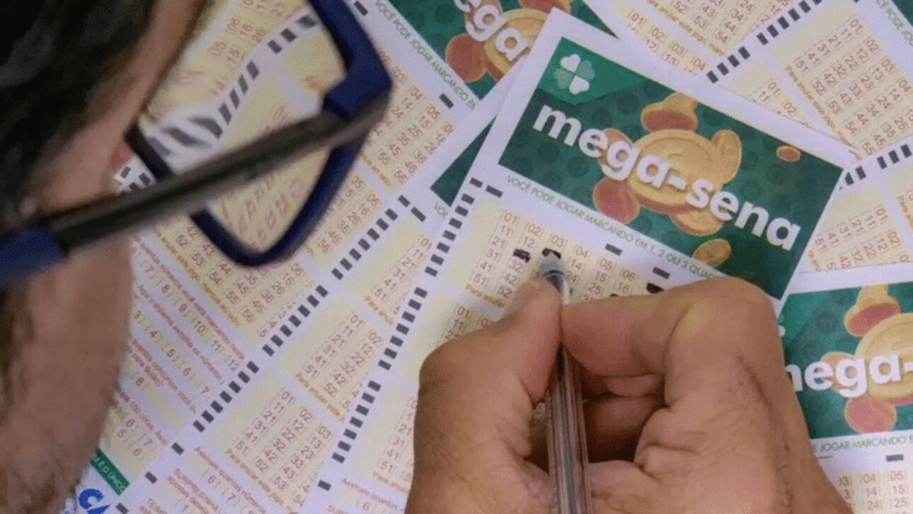 Billete de la Mega-Sena siendo sostenido por mano humana: referencia al premio que permitió la donación de R$ 101 mil. (Imagen: reproducción)