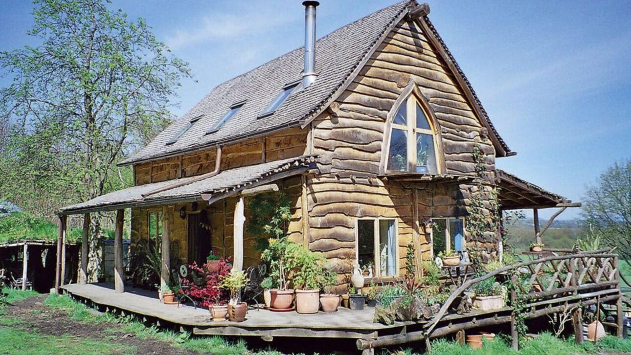 Leñador construye casa en el bosque con madera local, paja y revoque de tierra, vive fuera de la red con energía solar y eólica y gana destaque en el programa Grand Designs.