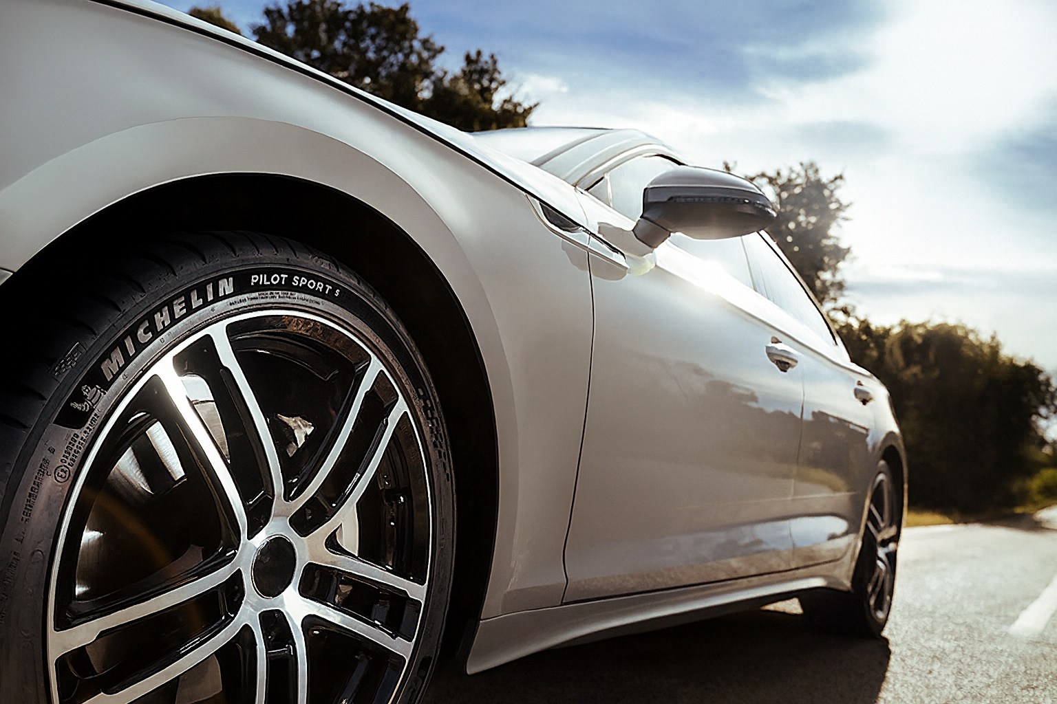 Pneu Michelin instalado em carro rodando em estrada, destacando tecnologia sustentável e eficiência no consumo de combustível