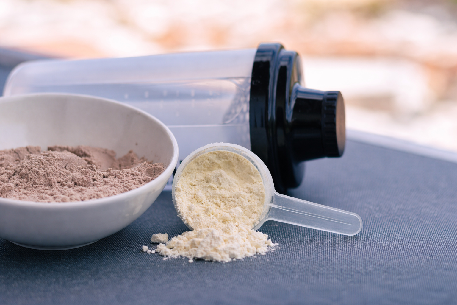 Pó de whey protein em colher medidora ao lado de shaker, ilustrando consumo de suplemento proteico e seus impactos na saúde renal.