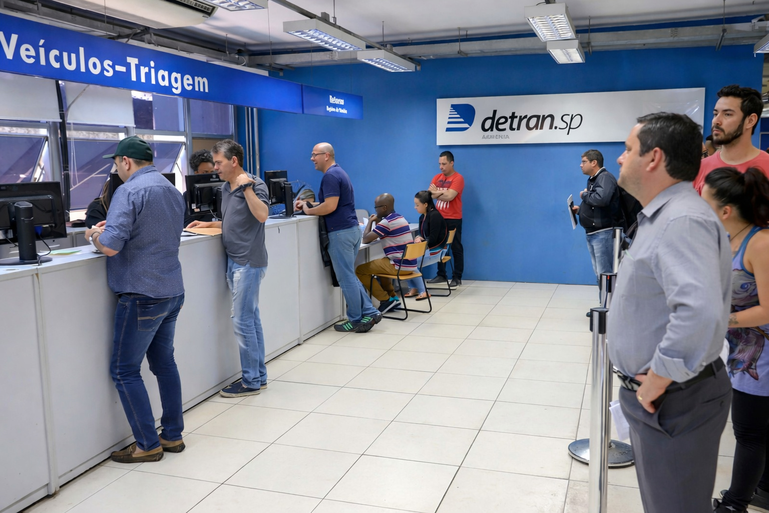 Atendimento no Detran-SP com cidadãos em fila no setor de triagem de veículos durante serviços de emplacamento Mercosul em São Paulo.