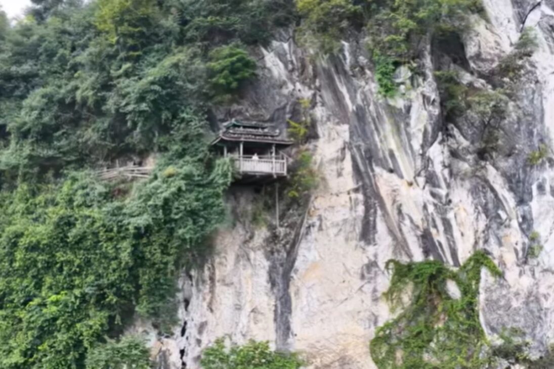 Casa colgada en un acantilado de 100 metros revela templo antiguo escondido en gruta gigante, escaleras deterioradas, pasarelas suspendidas y misterios impresionantes