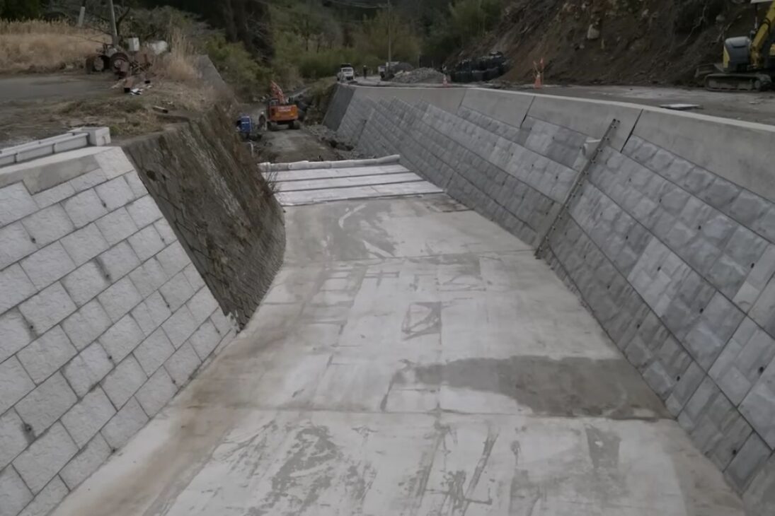 ingenieros japoneses unen concreto y cofragem en el lecho del río para reducir erosión y contener inundaciones, con obras discretas que guían afluentes y refuerzan la orilla principal.