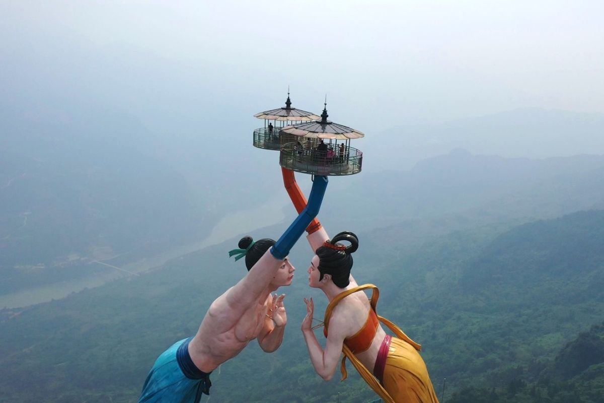 Escultura Beijo Voador vira fenômeno ao suspender visitantes sobre o Wujiang, com pratos que sobem e giram em grande altura no penhasco, gerando medo, risos e debates sobre engenharia e design ousado.