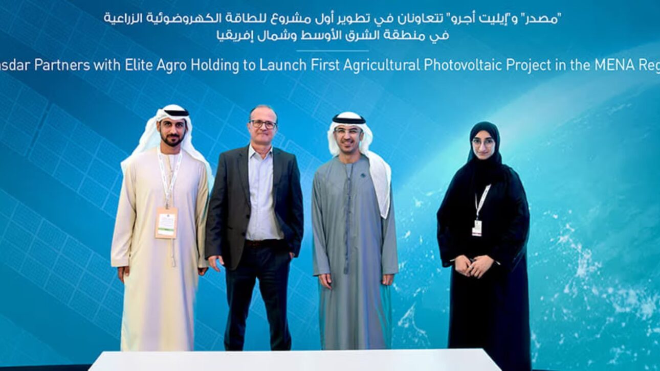 Cuatro representantes de Masdar y Elite Agro Holding frente a un panel azul anunciando la colaboración para el primer proyecto de energía fotovoltaica agrícola en la región MENA.