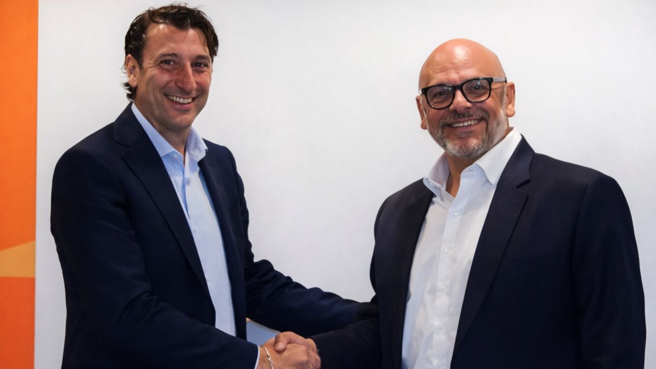 Ejecutivos de empresas del sector industrial estrechan manos durante el anuncio de una asociación estratégica en un entorno corporativo.