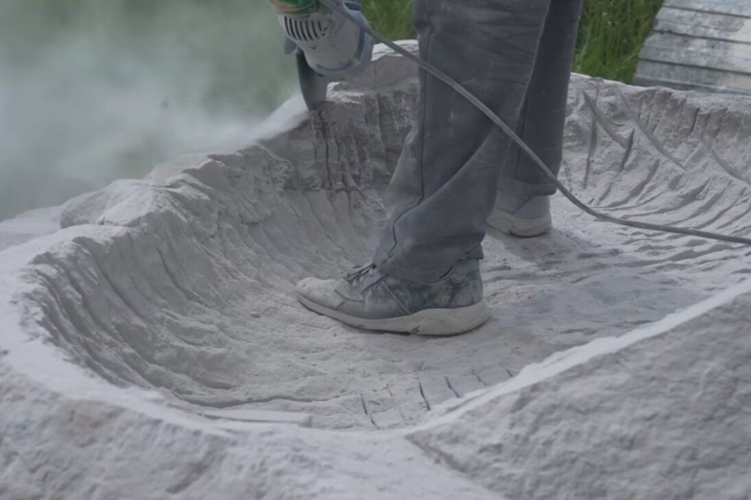 La bañera de piedra esculpida a mano a partir de granito y de una roca de 23.000 libras consumió meses, muchos disco de corte y pulido y una rutina intensa contra polvo, riesgos y lesiones en taller al aire libre.