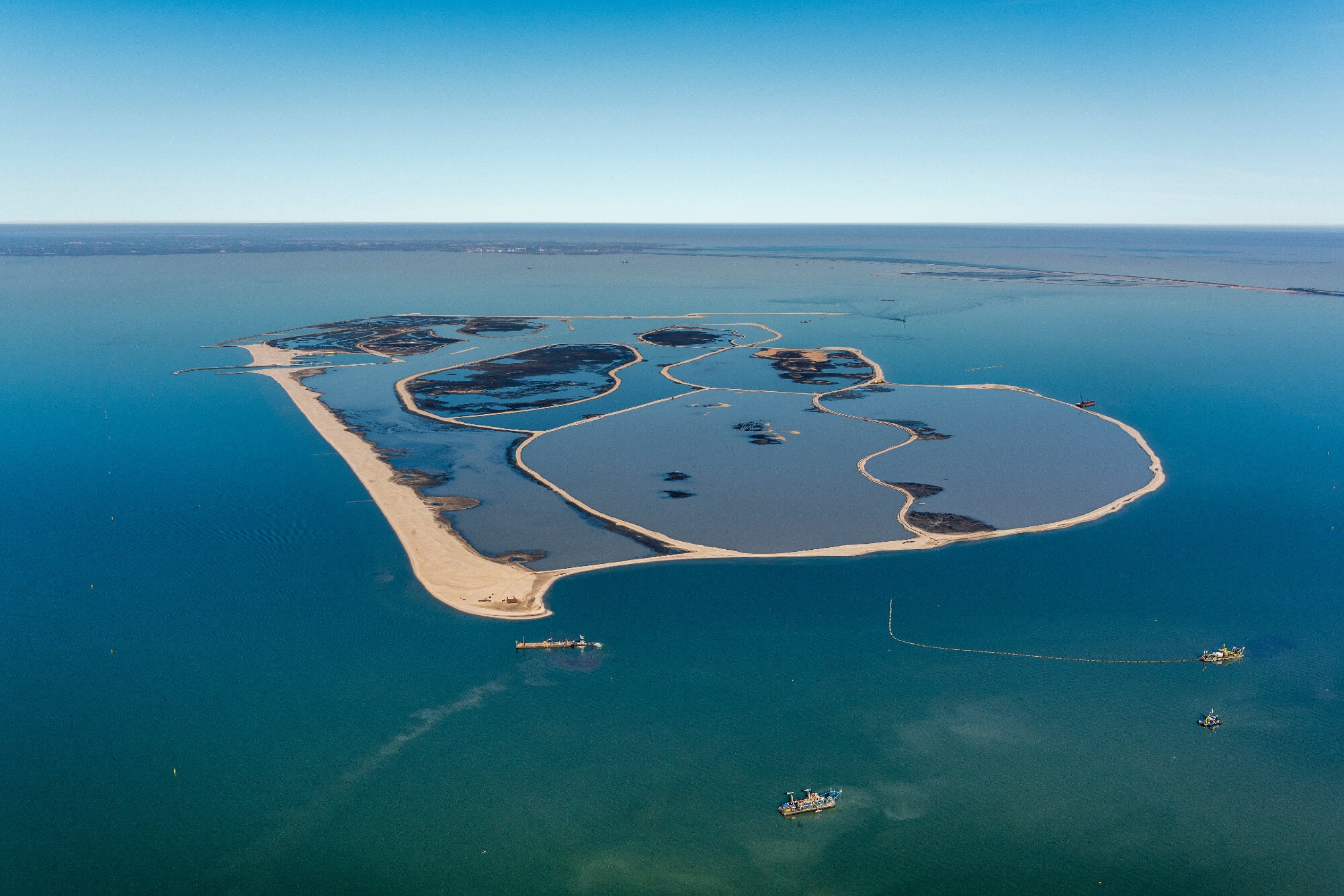 Para reverter 100 anos de erosão no Markermeer, a Holanda dragou mais de 28 milhões de m³ de sedimentos, moldou ilhas artificiais inteiras e transformou um lago turvo em um arquipélago vivo para aves, peixes e plantas