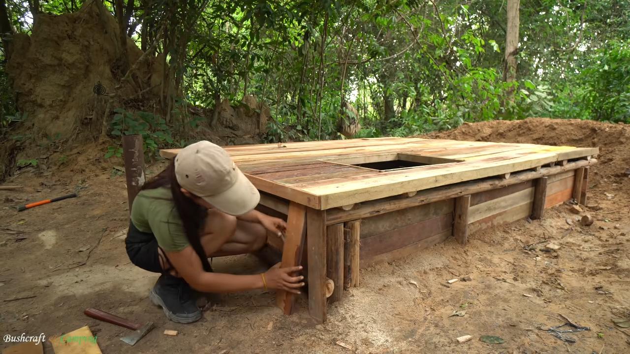 En apenas 32 días, mujer construye casa subterránea de madera totalmente autosuficiente, vive fuera de la red eléctrica y crea refugio oculto en la naturaleza