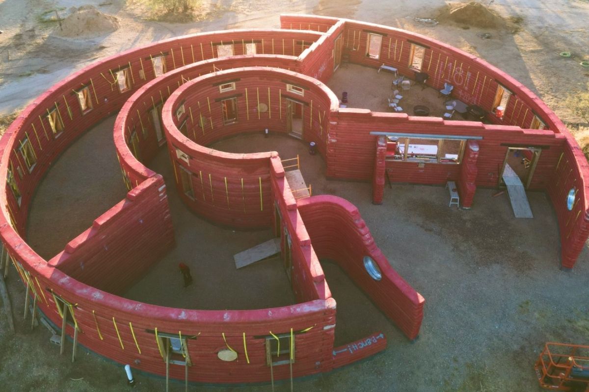 casa de terra no deserto com Hyper Adobe, sacos de terra, casa circular e telhado metálico para resistir a monções e fogo.