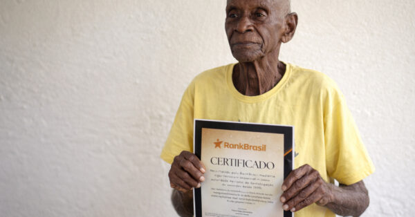 Idoso brasileiro de 118 anos segura certificado do RankBrasil após ter idade verificada em cartório.