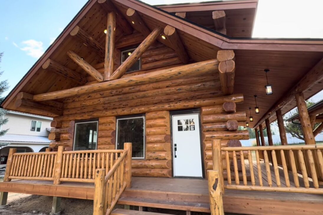 Cabaña de madera Denali 24x32 usa troncos más grandes, techo abuhardillado y aislamiento en el techo, con cochera cubierta integrada, para entregar eficiencia térmica, diseño con loft y soluciones de mantenimiento en un conjunto rústico y técnico.