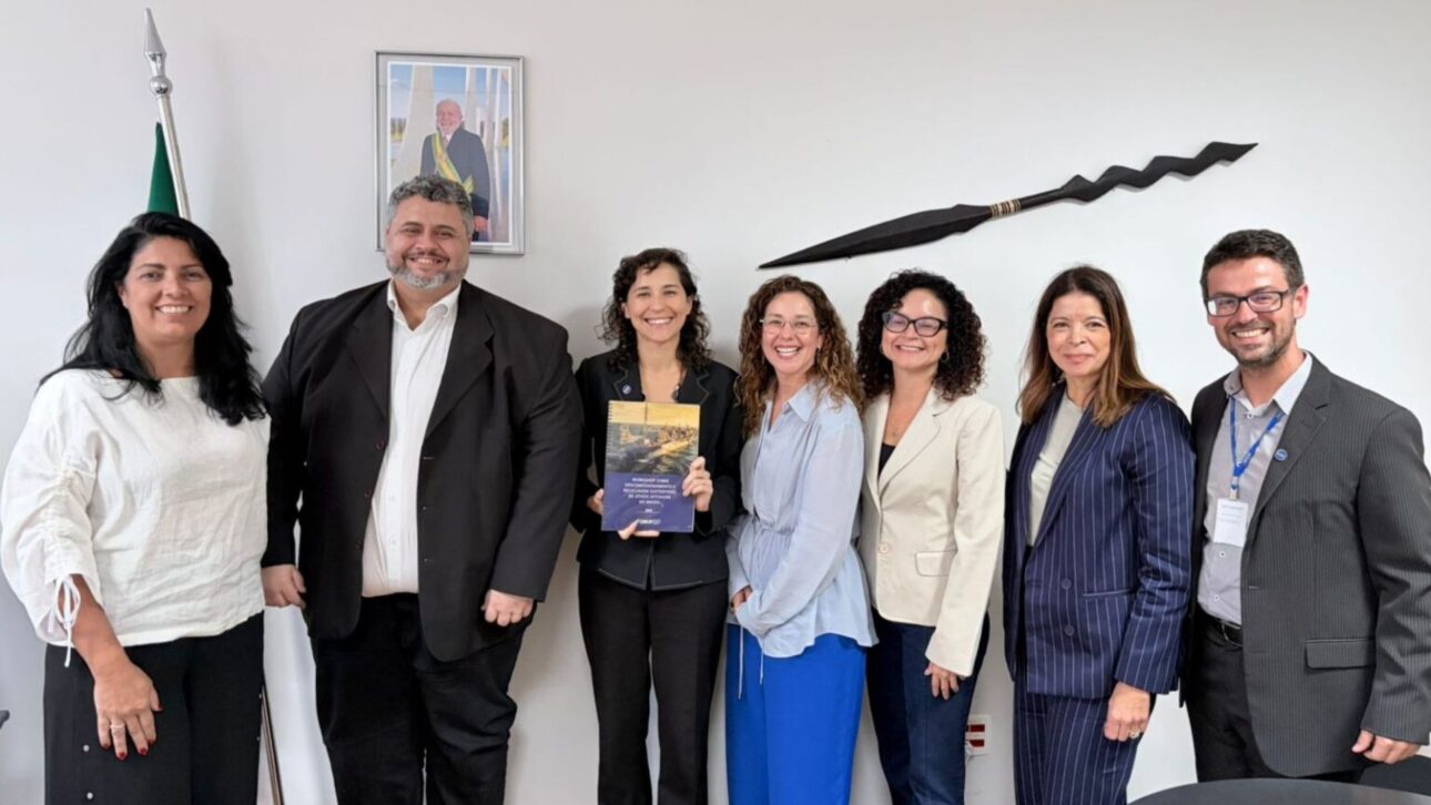 Grupo de representantes institucionales reunidos en oficina durante entrega de documento técnico sobre descomisionamiento offshore en Brasil.