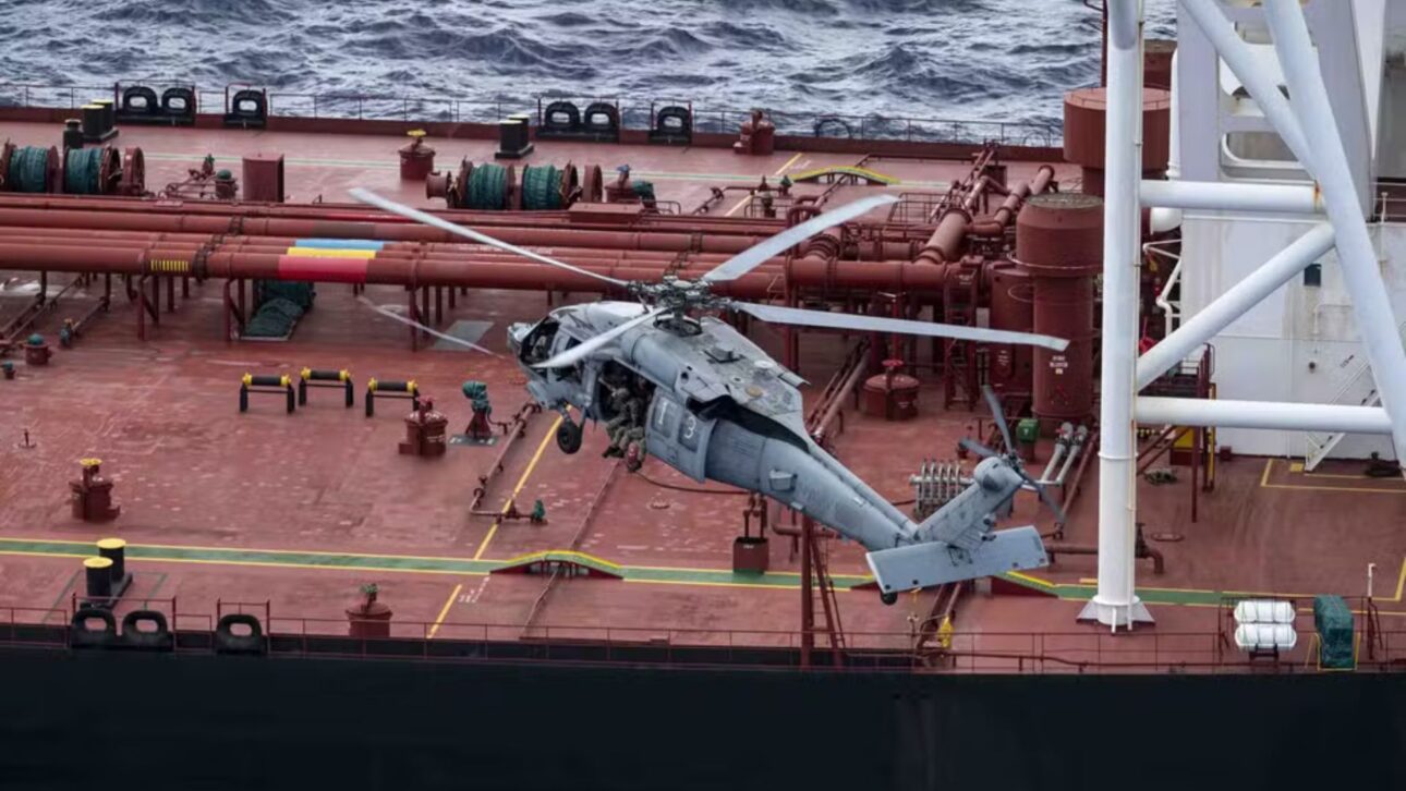 Helicóptero militar sobrevuela el convés de un petrolero en mar abierto durante operación de abordaje y fiscalización marítima.