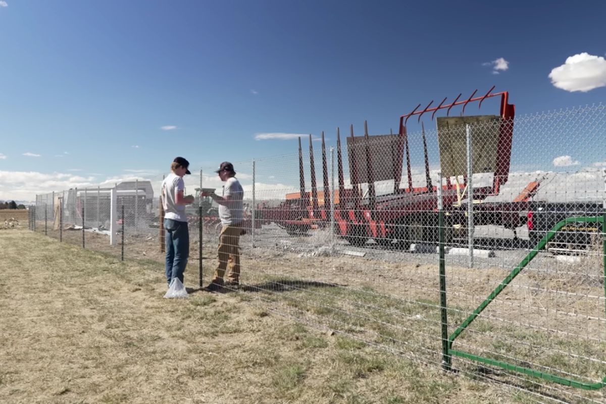 cerca para fazenda montada com postes mínimos, fio de alta resistência, corrente e tensionador: entenda por que o sistema segura tensão, reduz folga e evita exagero técnico em terrenos difíceis.