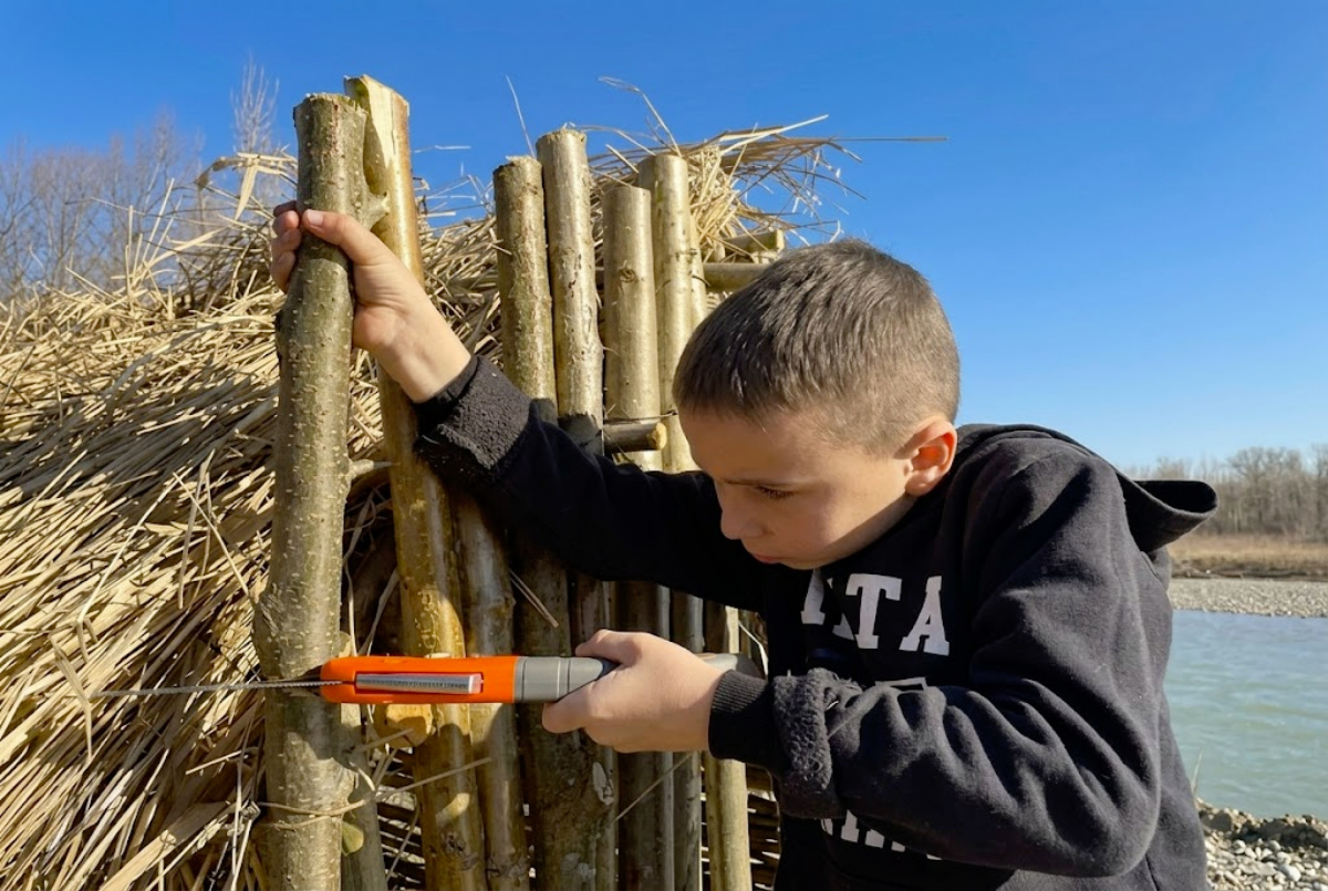 Menino de 12 anos constrói sozinho uma cabana à beira de um rio com galhos e madeira de árvores pequenas, usando poucas ferramentas e técnica de construção genial para encaixar as peças que ele mesmo criou